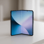 in modernes, geöffnetes Falt-Smartphone (ähnlich dem Galaxy Z Fold), das in einer hellen, klaren Umgebung auf einem eleganten, minimalistischen weißen Tisch liegt.